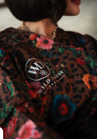 Wild Daisy Salon branded leopard-and-floral cape worn by client