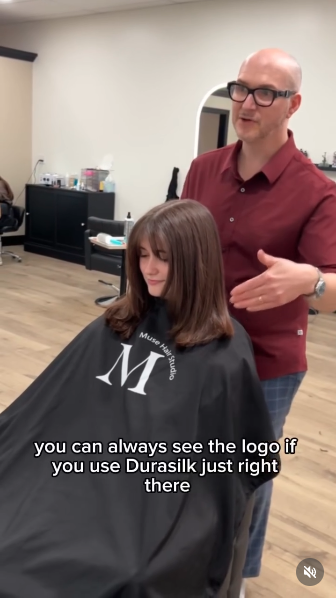 Muse Hair Studio branded black cape on client mid-cut